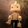 Roro the wooden robot sitting in the nature