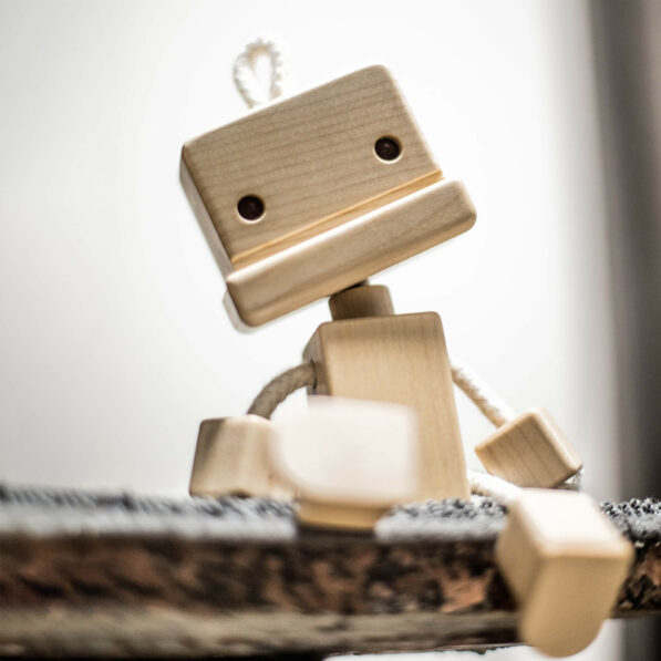 The Wooden Robot Roro sits on a table with tilted head