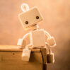 Wooden robot sitting on wooden shelf