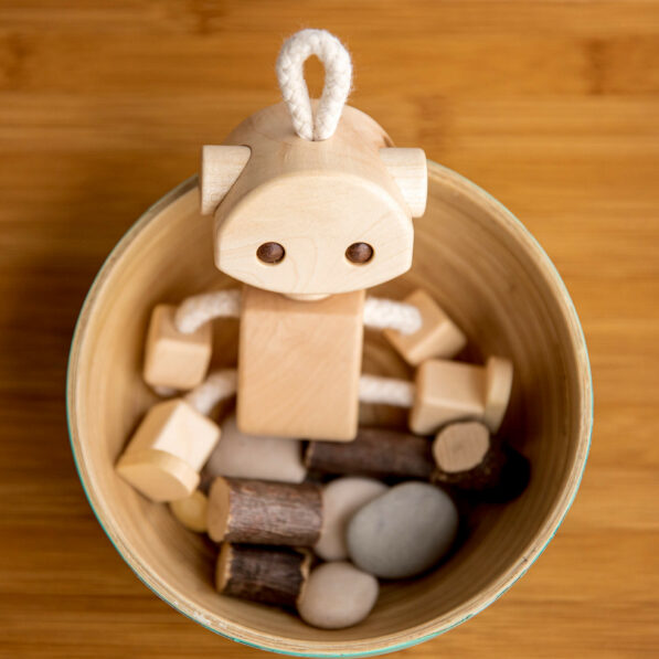 Wooden robot toy sitting in wooden cup