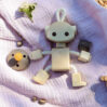 Wooden robot toy on pink baby blanket