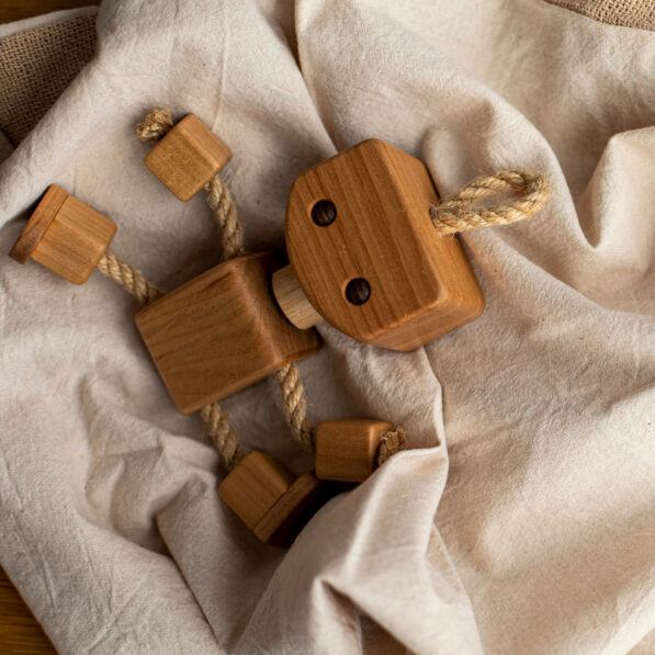 Wooden robot toy lying on blanket