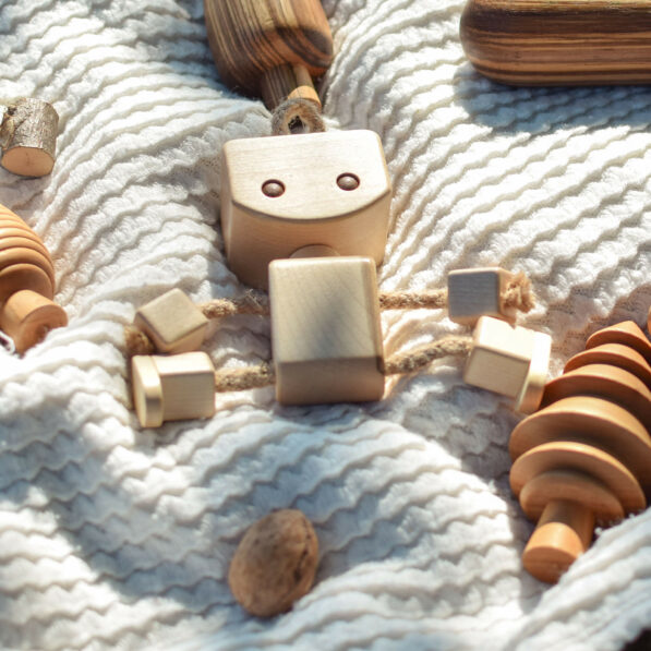 Wooden robot toy on white blanket