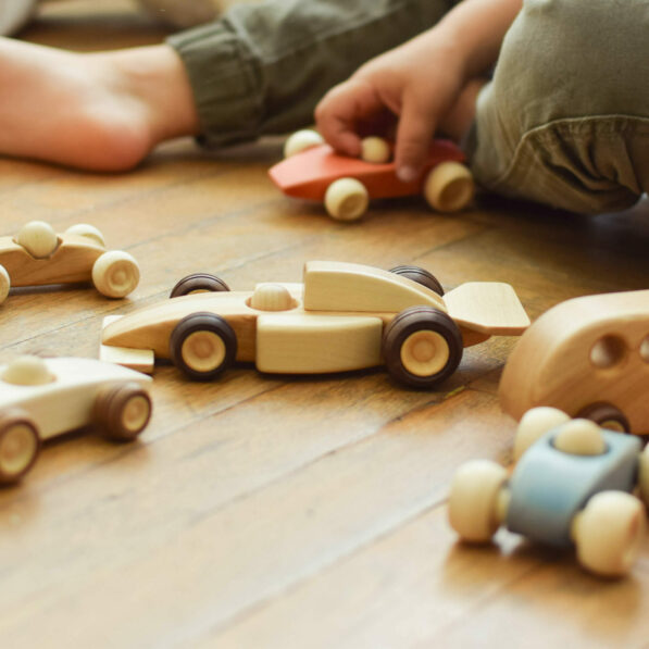 Wooden cars and kid palying in the background