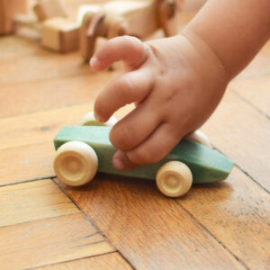 kid hand holding wooden toy car