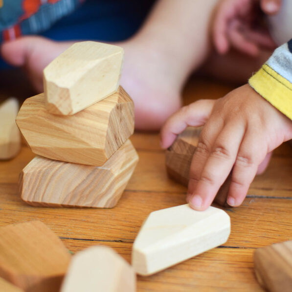 baby hand building tower of wooden blocks