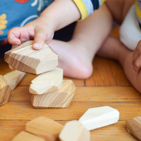 baby hand building tower of wooden blocks