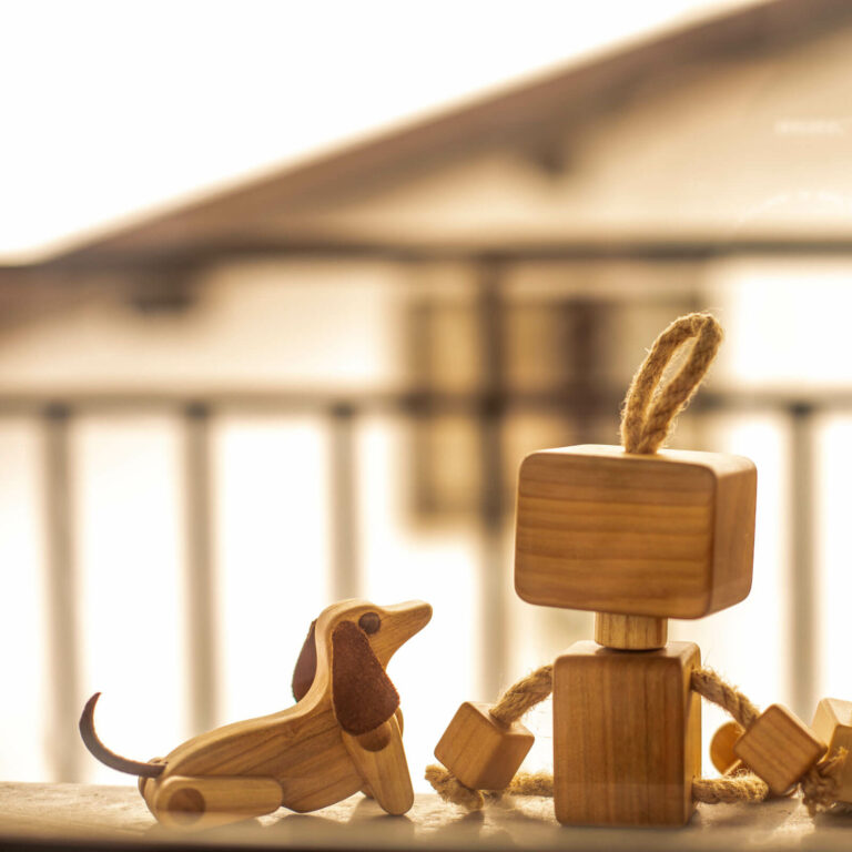 Wooden dog sitting next to wooden robot