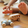 Kid playing with wooden cars