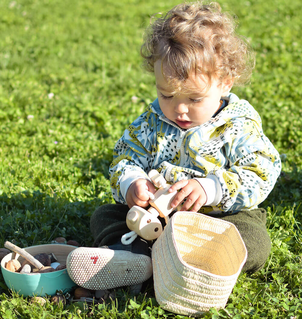 baby holding open ended wooden toy