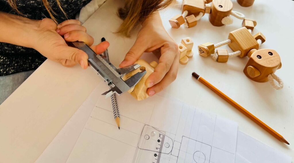 hands measuring wooden toy