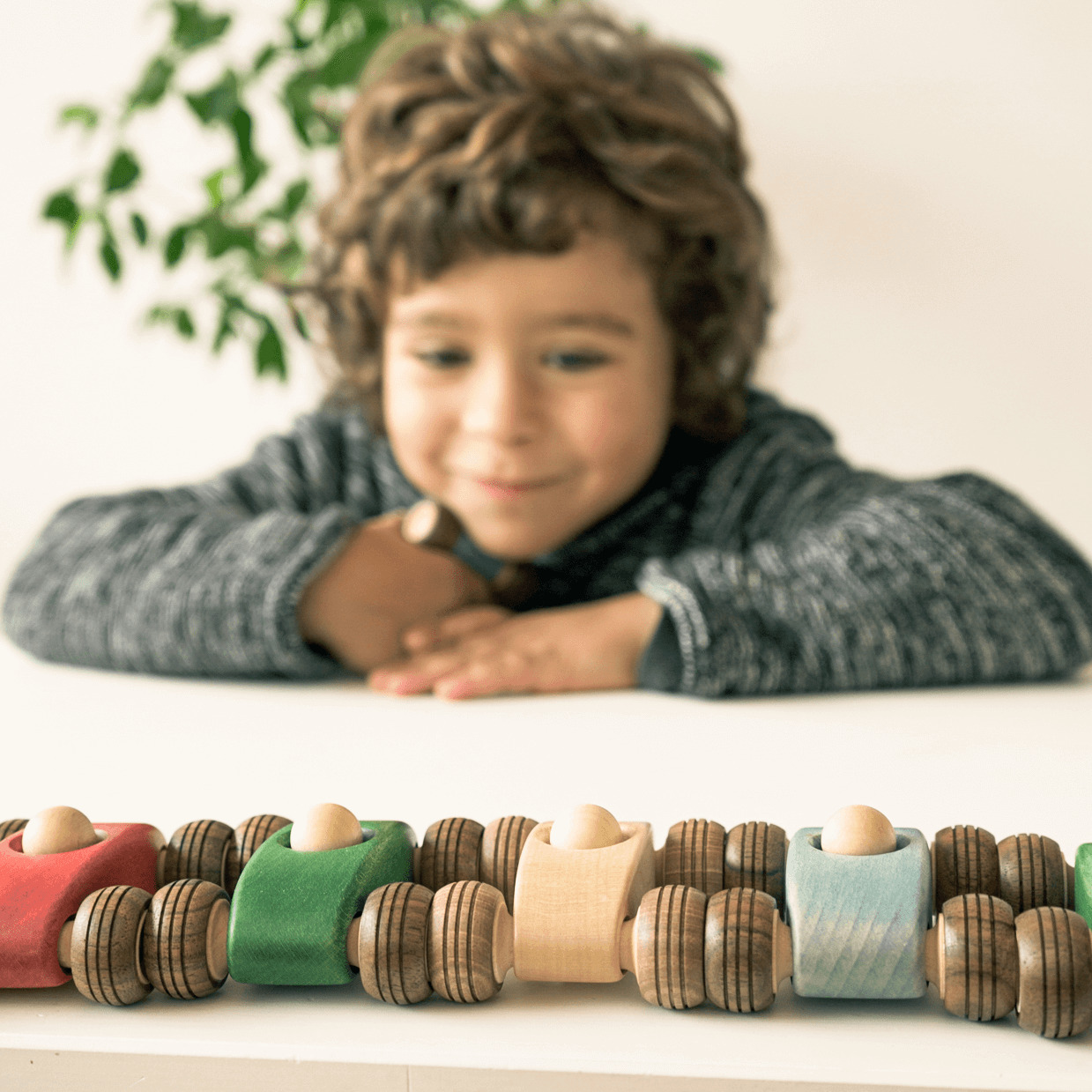 happy kid looking wooden cars